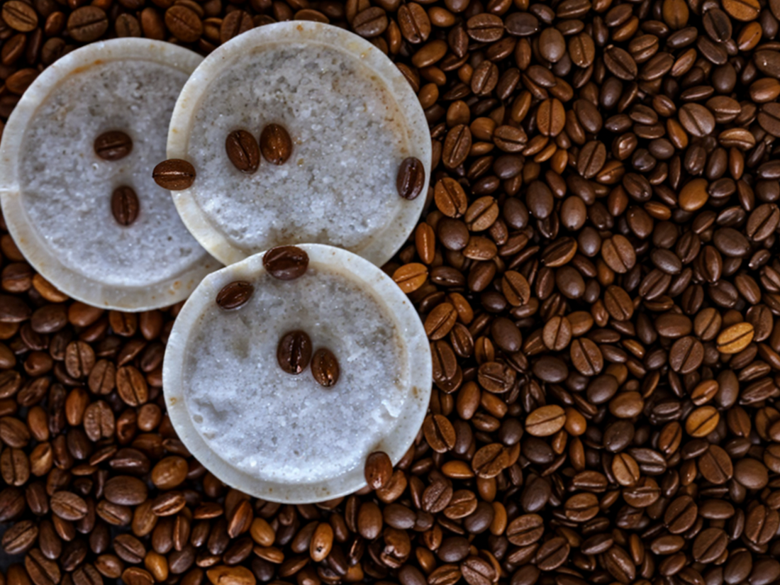 Cialde ESE 44mm in carta filtro appoggiate su chicchi di caffè tostati